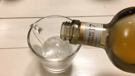透明まる氷にウイスキーを入れる画像